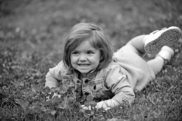 Sourire d'enfant sur l'herbe verte — Photo