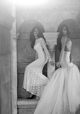 Şatodaki düğün töreninde gelin kızlar. Gelin kadınların poz taşlı column yakınındaki şaşırtıcı elbiseli.