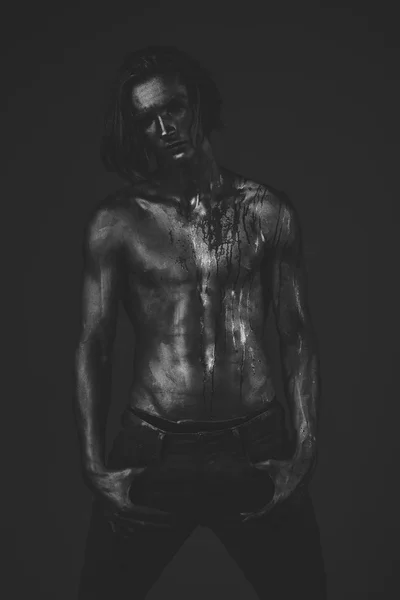 Человек с обнаженным туловищем, покрытым мерцающей серебряной краской — стоковое фото
