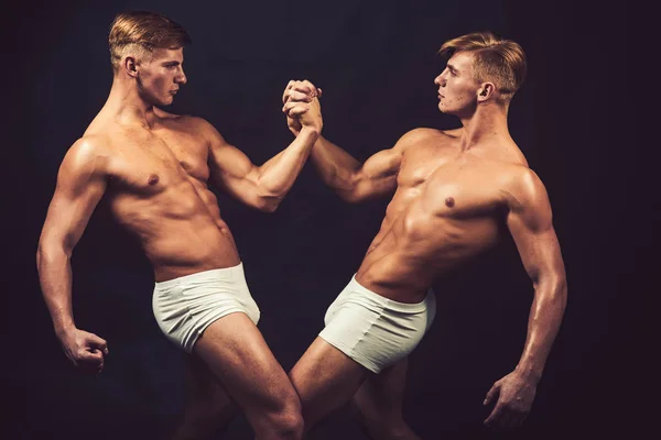 Männerfreundschaften turnen. Freundschaft der Zwillinge Männer mit muskulösem Körper in Bodybuilder-Pose. — Stockfoto