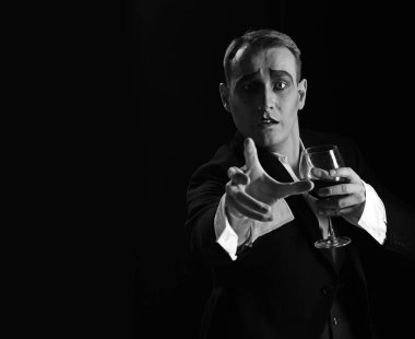 Neredesin. Sahne aktör pandomim şarap içme. Komedyen MIME makyaj ile şarap kadehi tutun. MIME sanatçı sahnede gerçekleştirin. Dram Tiyatrosu aktör miming. Tiyatro performans sanatı ve reis komedi