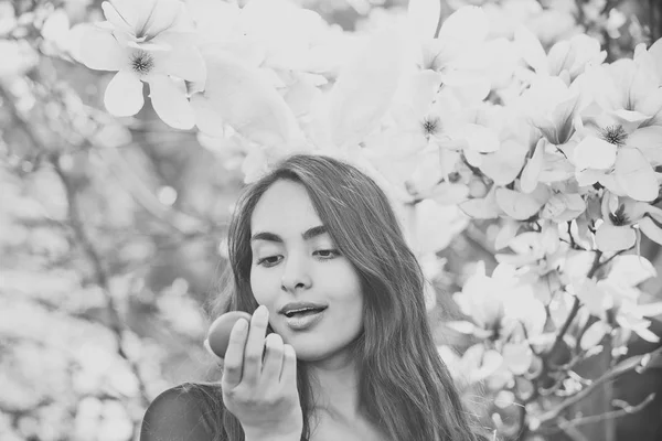 Oeuf à la main de femme aux lèvres moelleuses, magnolia — Photo