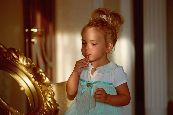 Дитяча дівчинка наносить червону помаду на губи — стокове фото