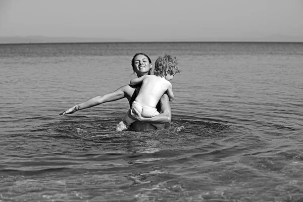 물에 아들 수영으로 어머니입니다. 카리브 해에 행복 한 가족입니다. 여름 방학과 바다 여행입니다. 몰디브 또는 마이애미 비치 활동 기쁨. 어머니 여자 부모의 손에서 어린 소년의 날 휴일. — 스톡 사진