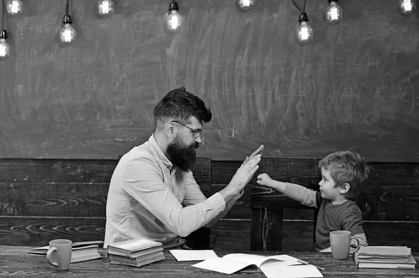 Knappe leraar en schattige jongen spelen in de klas. Schooljongen bereiken van de taak. Kleine kampioen aanhef — Stockfoto