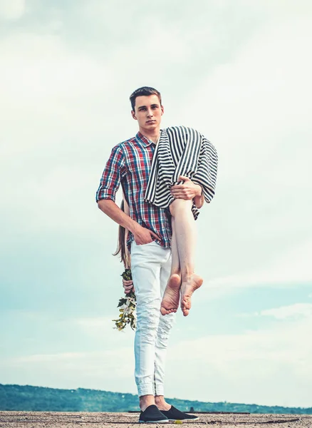 El hombre lleva a una chica en el cielo. caminando al aire libre. cansado después de un día agotador. viajes de senderismo. pareja enamorada. pareja joven al aire libre. hombre y mujer en camino. Ella es mi presa. Problemas en las relaciones —  Fotos de Stock