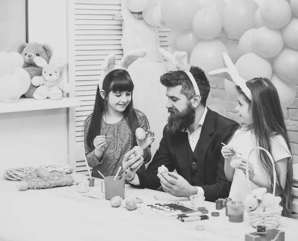 Father and daughters paint handmade egg.