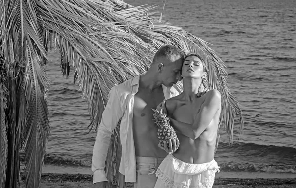Sexy junges leidenschaftliches Paar mit Ananas. Sommer-Stil. in warmen Farben getönt — Stockfoto