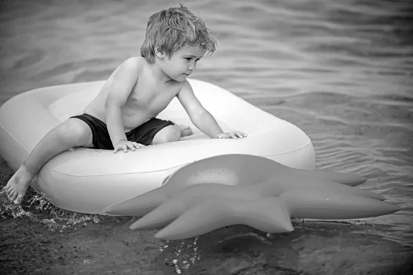 Vacaciones de verano y viajes al océano. Niño pequeño baño de sol en el colchón de aire. Colchón inflable de piña, actividad y alegría. Maldivas o agua de playa de Miami. niño pequeño en el mar Caribe en Bahamas . — Foto de Stock