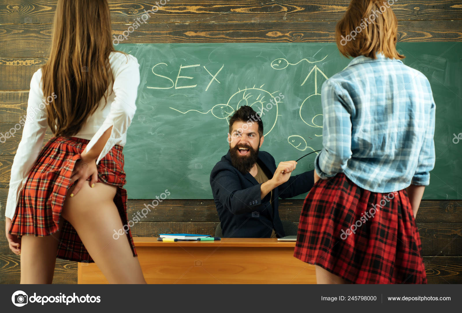 Symbols on chalkboard. Lesson and sex education in high school. Sexology teacher looks at two sexy female students pic