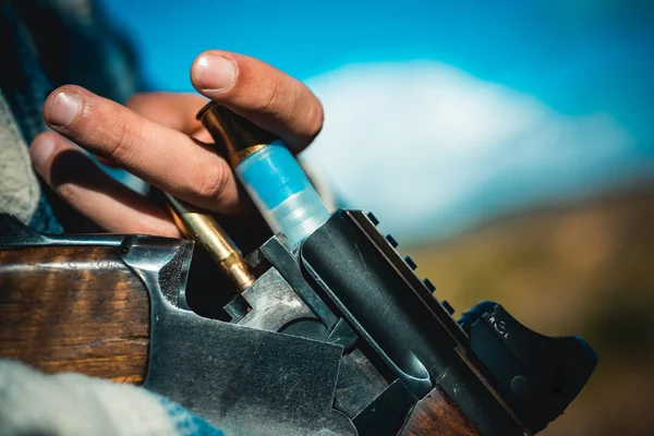 Hunting Licenses. Hunter with shotgun gun on hunt. Hunter in the fall hunting season. Man is charging a hunting rifle. Hunting gun.