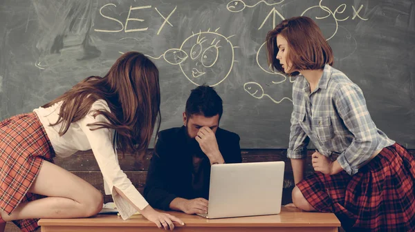 Seksowna edukacja. Nauczycielka sexologii z brodą patrzy na dwie seksowne uczennice. Edukacja erotyczna i sex Symbole na tablicy. — Zdjęcie stockowe