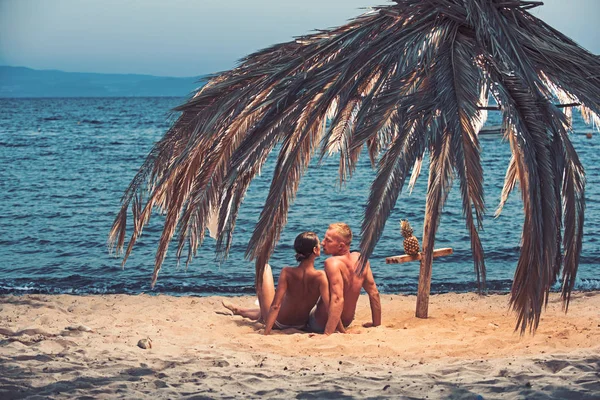 Familia y día de San Valentín. Vacaciones de verano y vacaciones de viaje paraíso. Las relaciones amorosas de la pareja desnuda sobre la arena. Mujer sexy y hombre con piña. Pareja enamorada de sexy cuerpo relajarse en la playa . — Foto de Stock