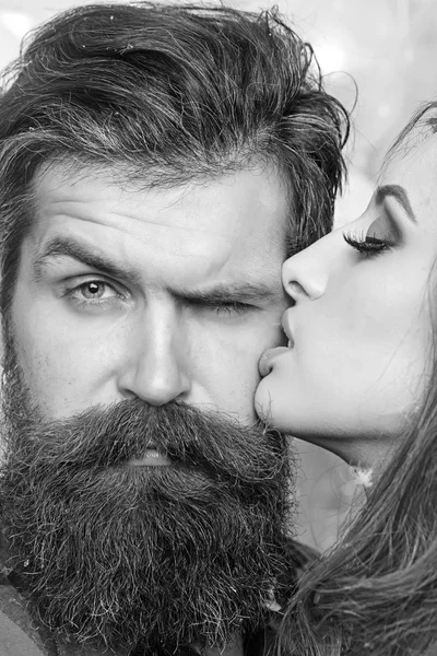 Beauty salon and barber shop. Sensual woman kiss bearded man, love. Woman with makeup skin and hipster with long beard. Couple in love and family concept. Skincare and hair care concept