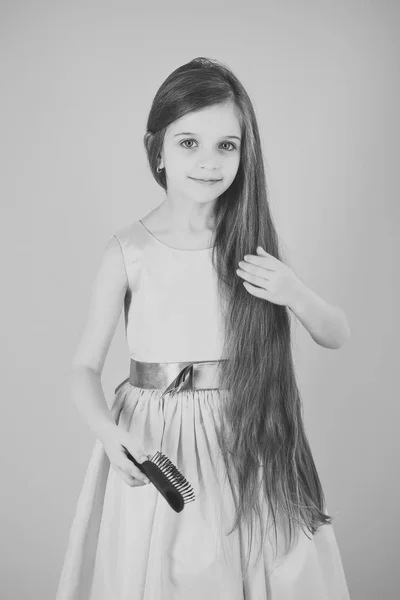 Flicka barn borsta hår i fashionabla klänning på rosa. — Stockfoto