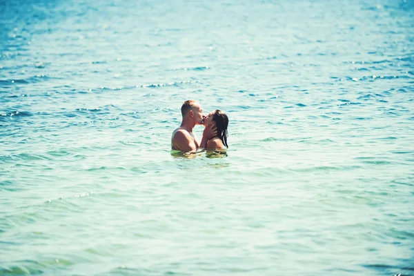 Família feliz na praia beijando na água . — Fotografia de Stock