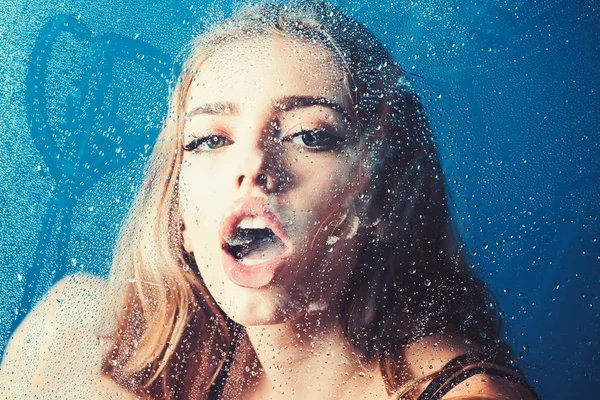 Fashion beauty and love. Window with water drops before girl with makeup. Shower and hygiene spa treatment. Rain drops on window glass in heart shape. Sexy woman behind plastic sheet with water drops