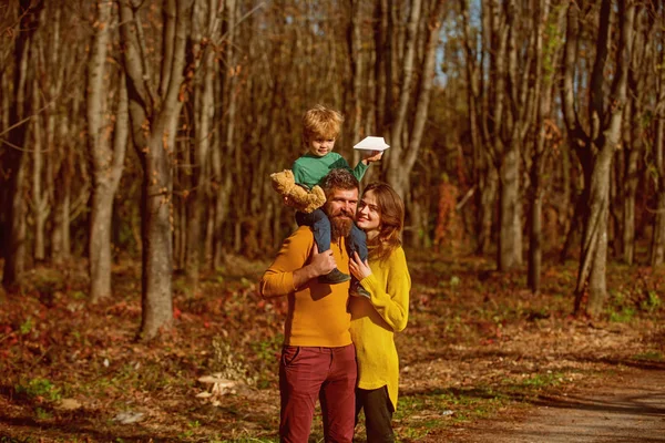 Madre e padre a cavalluccio piccolo figlio godere di una giornata di sole nel parco durante le vacanze avventura. L'avventura è là fuori. Godetevi la libertà — Foto Stock