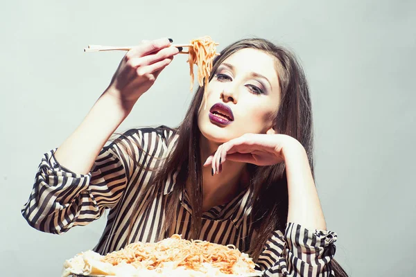 女の子は、トマト ケチャップを使ったパスタ料理を食べる。女の子は、イタリア料理の食事を持っています。 — ストック写真