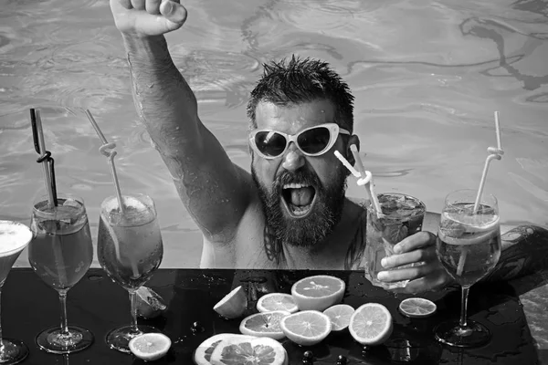 男のスイミングや飲み物のアルコール。プール パーティー、ビタミンとダイエットします。マイアミやモルディブでは夏休み。プールのひげを生やした男でフルーツ カクテル。海とスパのリゾートでリラックスします。. — ストック写真