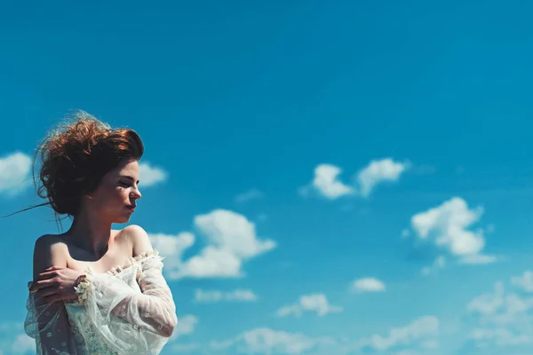 Make-up op jonge gezicht. Beauty en fashion kijk in vintage stijl. Mooi meisje in witte trouwjurk en retro kapsel. Mode vrouw model pose buiten. Meisje op de achtergrond van de zonnige blauwe hemel in de zomer. — Stockfoto