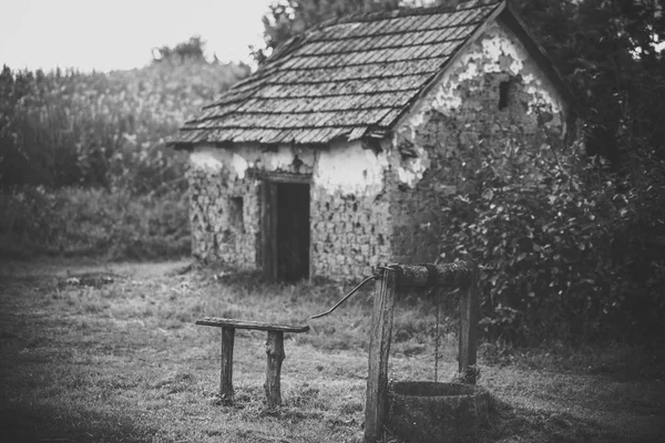 Dom baraku z stara studnia w stoczni — Zdjęcie stockowe