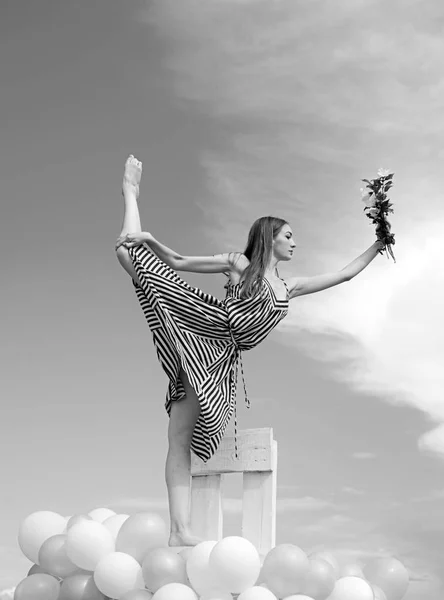 Γυναίκα στο καλοκαιρινό φόρεμα με μπαλόνια κόμμα. το κορίτσι με τα λουλούδια κάθονται στον ουρανό. αίσθηση ελευθερίας και το όνειρο. έμπνευση φαντασία. Μόδα Πορτρέτο γυναίκας. Σπλιτ. χορεύει στον ουρανό. αθλητισμό και την επιτυχία — Φωτογραφία Αρχείου