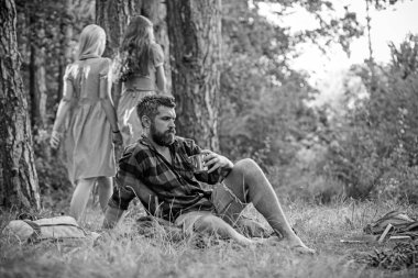 Kamp ateşi ile kahve veya çay içme sakallı adam. Retro elbiseler woods, yolda yürürken iki kız geri dön. Rahatlama ve huzur kavramları