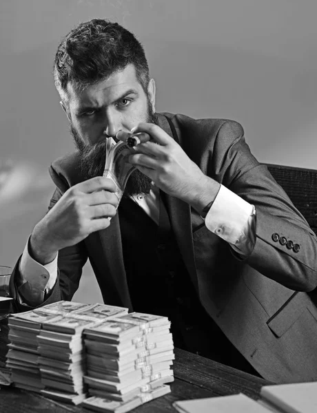 Money and power. Business and finance. Bearded man count dollars while smoking cigar. Successful businessman hold cash money. Rich man with beard in formal wear. Growing a business