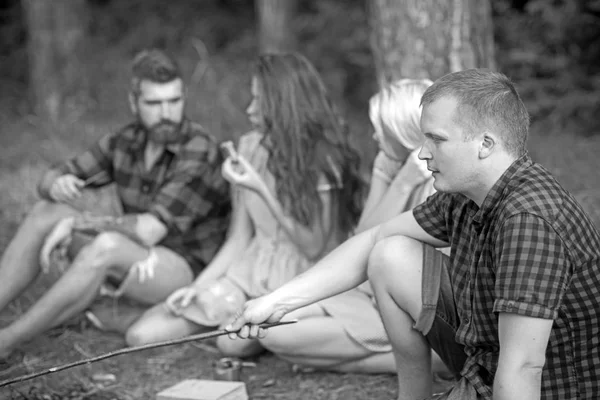Man relax with friends in summer forest. Macho in plaid shirt on nature. Tourist enjoy camping. Summer vacation concept. Camping, travelling and wanderlust