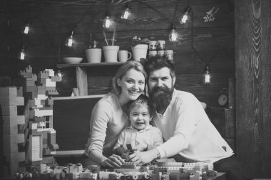 Ebeveynler hugs, oynarken oğlu izlerken, ebeveynlik zevk. Anne ile çocuk oyun plastik bloklar ile Yapı İnşaat. Baba, anne ve sevimli oğlu Oluşturucu tuğla ile oynamak. Aile Eğlence kavramı.