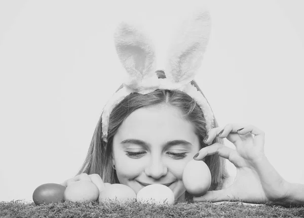 Dziewczyna uśmiecha się z malowane jajka na zielonej trawie, wiosna — Zdjęcie stockowe