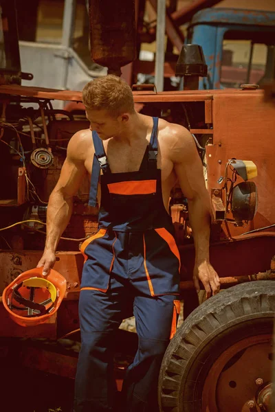 Craftsman concept. Craftsman rest at tractor cabin. Strong craftsman in working uniform at heavy construction machine. Craftsman at backhoe loader — Stock Photo, Image