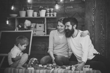 Mutlu anne her diğer oğlu bakarken sarıl. Aile Divan plastik bloklarla oynama. Yan görünüm konsantre çocuk oyuncak tren ile çalış