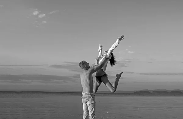 Love relations of naked couple at sea. Summer holidays and paradise travel vacation. Happy family and valentines day. Sexy woman and man jump. Couple in love with sexy body relax on beach.