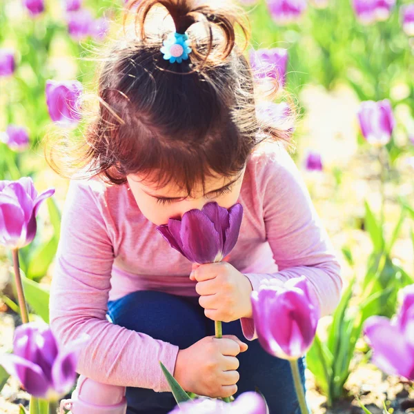 Kis gyerek. Természetes szépség. Gyermeknap. arc- és bőrápoló. allergia-virágok. Tavaszi tulipán. Időjárás-előrejelzés. Nyári lány. Boldog gyermekkor. Napsütéses tavaszi kislány. Élvezi a tavasz — Stock Fotó