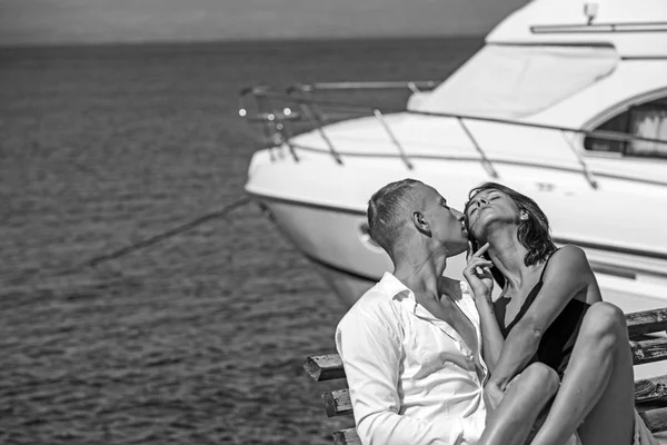 Casal apaixonado relaxar no iate para viagens marítimas. casal apaixonado por homem beijo mulher sentado no banco perto de iate . — Fotografia de Stock