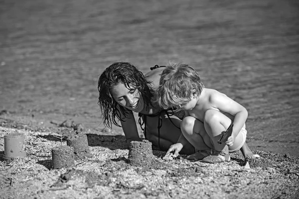 Mamma med son gör sand slott vid havet. Lycklig familj på Karibiska havet. Sommarsemester och resa till havet. Maldiverna eller Miami beach aktivitet glädje. Mödrar dag semester av lilla pojke och kvinna förälder. — Stockfoto