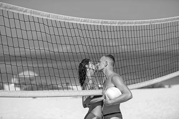 Amor e flerte de casal. Mulher sexy e homem musculoso com bola na net. Férias de verão e viagens de férias em Miami. Casal apaixonado jogar vôlei na praia ensolarada. Actividade desportiva e saúde — Fotografia de Stock