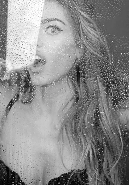 Fenêtre avec gouttes d'eau avant fille avec maquillage. Traitement spa douche et hygiène. Femme sexy derrière une feuille de plastique avec des gouttes d'eau. Mode et beauté. gouttes de pluie sur le verre de fenêtre avec le visage de la fille — Photo