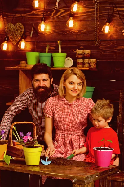 Save Earth Konzept. Kleiner Junge mit Familie pflanzt Blumen in neuen Topf, um die Erde zu retten. Kind mit Mutter und Vater, die Zimmerpflanze im Dreck verpflanzen, um die Erde zu retten. Erde retten und sicher halten — Stockfoto