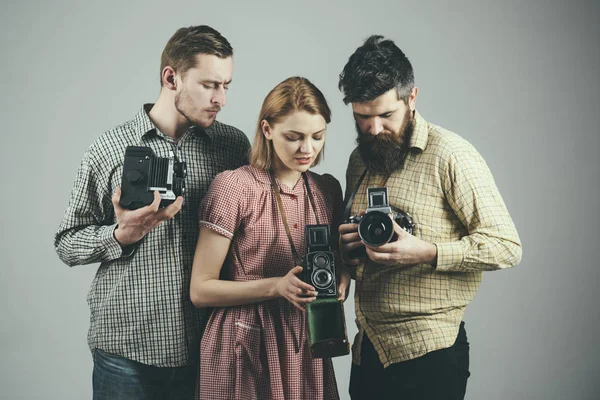 Aprender a guardar recuerdos. Grupo de fotógrafos con cámaras retro. Paparazzi o fotoperiodistas con cámaras vintage. La mujer y los hombres de estilo retro tienen cámaras de fotos analógicas. Estudio de fotografía —  Fotos de Stock