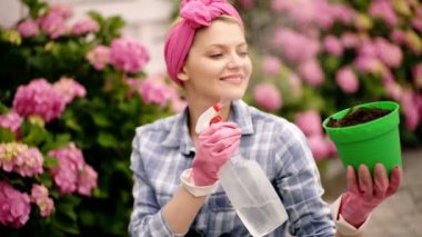 Kadın çiçek bahçesinde bak. mutlu kadın bahçıvan çiçekli. Sera çiçekler. Ortanca. Bahar ve yaz. Çiçek bakım ve sulama. Toprak ve gübre.