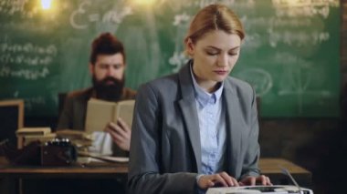 Giyen kadın daktilo okul yönetimi ve kitap okuma adam arka plan üzerinde tarih yazarak metin uygun. Akıllı insanlar bir okul sınıf yeşil ışık yanmadı çerçevede çalışır. Öğrenme kavramı.