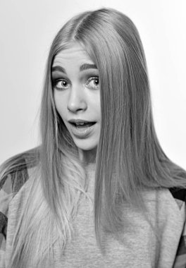 Kalın kaşları ve beyaz arka plan üzerinde izole Studio poz parlayan uzun sarı saçları ile neşeli genç kadın