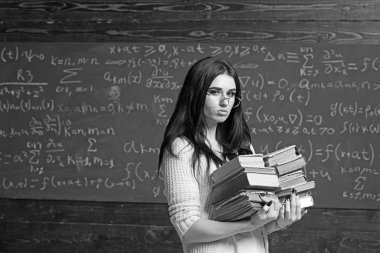 Ciddi kız genç öğrencinin sınav önce. Esmer kız bardaklarda iki kazık ağır kitap taşıma