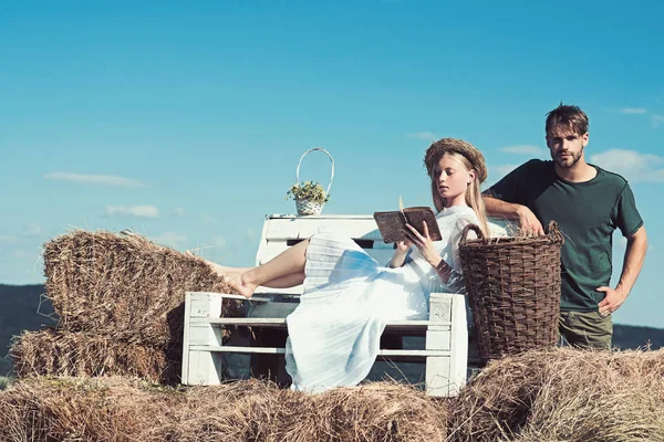 Sensual woman read book for man. Woman bride in wedding dress relax on bench. Couple in love on vacation. Family enjoy summer nature. Girlfriend and boyfriend date outdoor