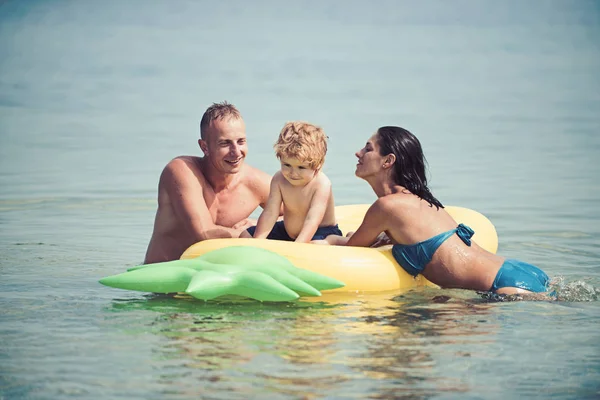 空気マットレスの上を泳ぐ幸せな家族の肖像画. — ストック写真