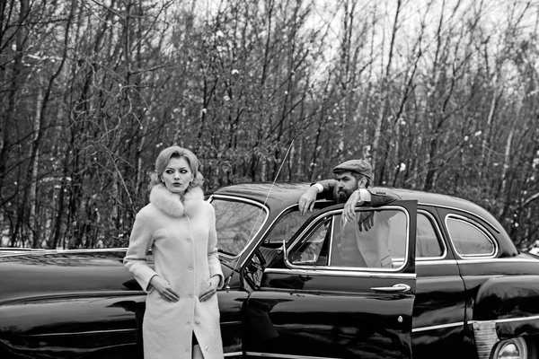 Retro raccolta auto e riparazione auto da parte del macchinista. Coppia innamorata ad un appuntamento romantico. Uomo barbuto e donna sexy in cappotto. Viaggi e viaggi d'affari o autostop. Escort di ragazza di sicurezza . — Foto Stock