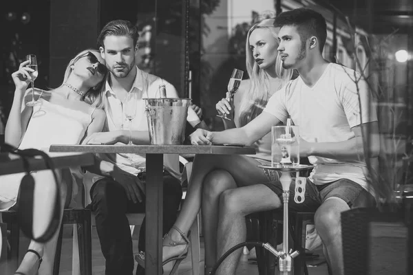 Gemelli donne e uomini rilassarsi in shisha caffè all'aperto — Foto Stock